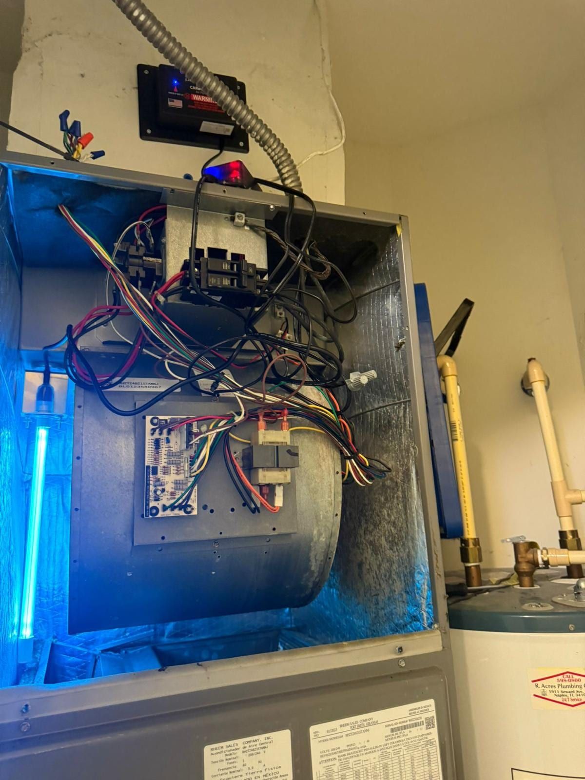 Air handler cabinet interior with a UV germicidal light lit beside the blower housing and control wiring